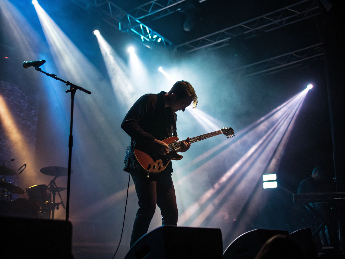 Solo musician playing guitar on stage
